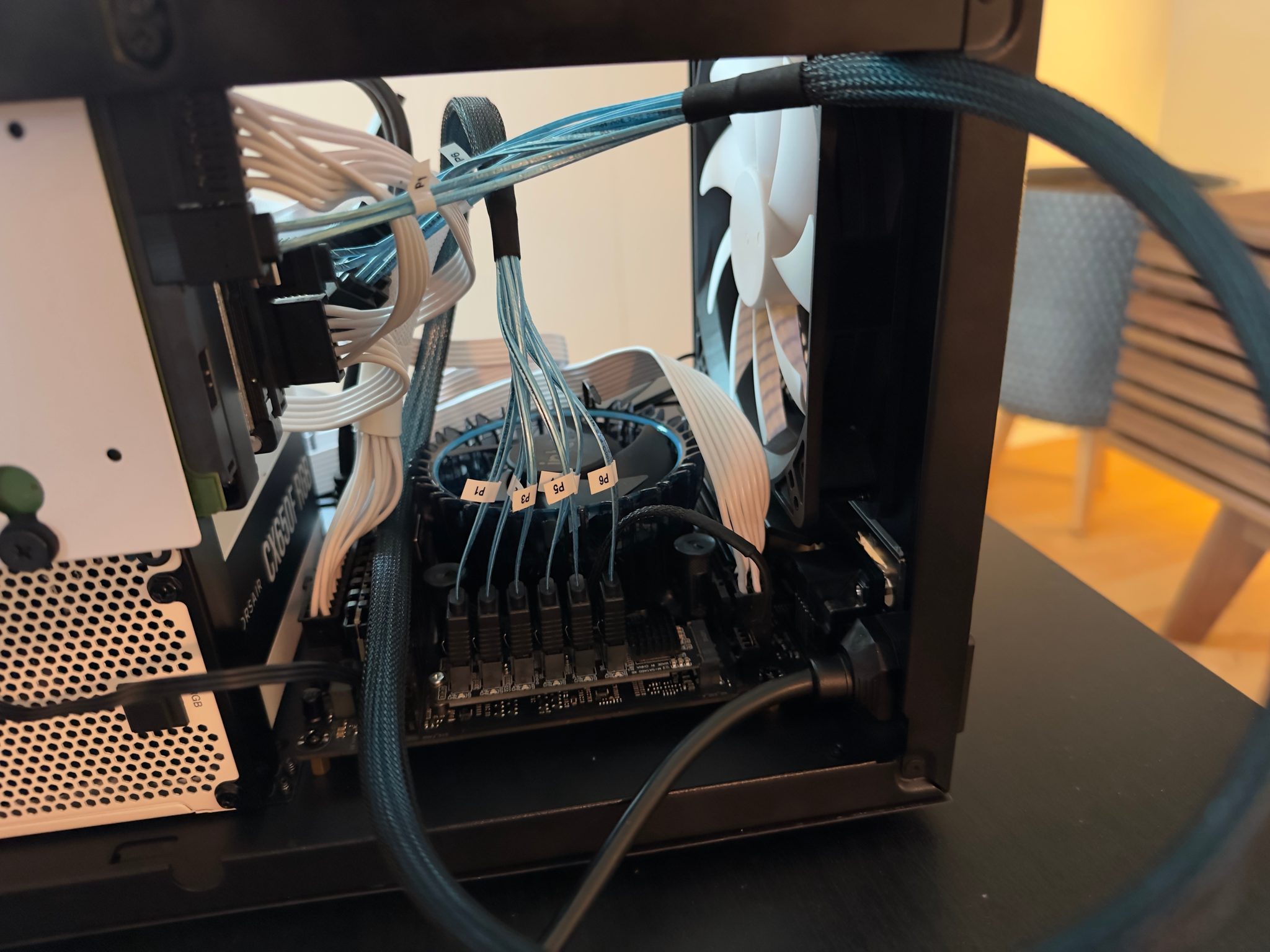 Inside the home server: labelled blue SATA cables, a low-profile CPU cooler, and a Corsair CX650M power supply
